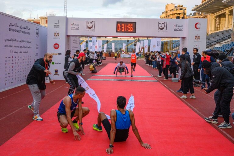 Runners sitting just outside the finish line at Zayed Charity Marathon Egypt 2022