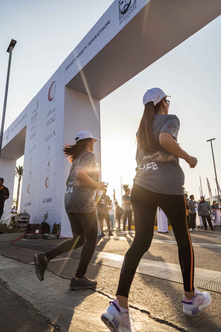Two female runners crossing the finish line at the Zayed Charity Marathon Abu Dhabi 2022