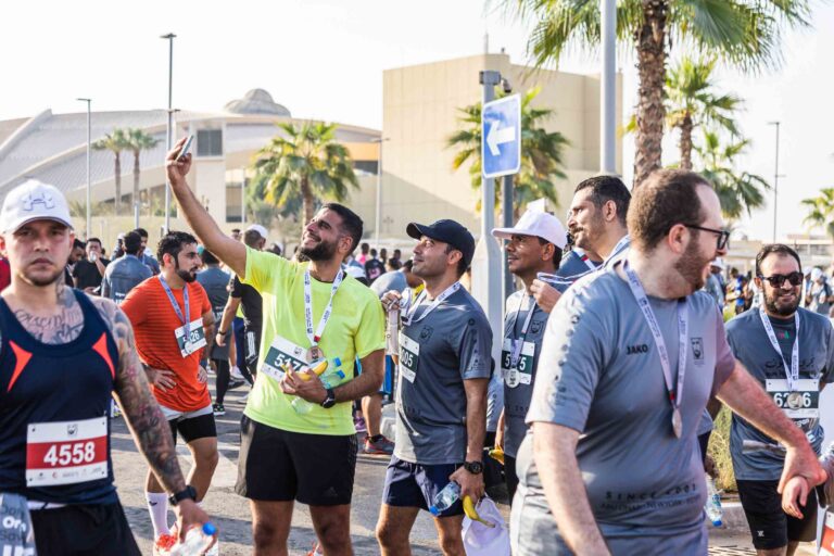 Runners taking selfies at the Zayed Charity Marathon Abu Dhabi 2022