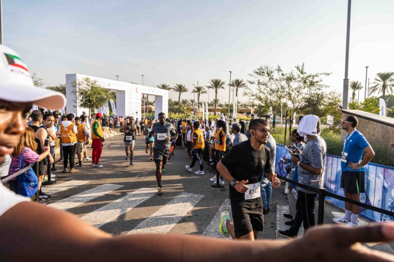 Runners passing through the finish line at Zayed Charity Marathon Abu Dhabi 2022